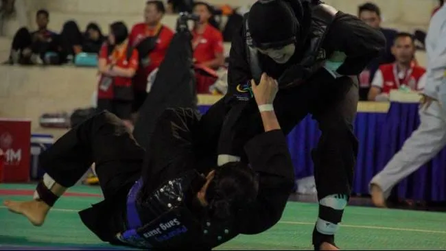 Pesilat Indonesia Delly Salsafitri (kanan) berusaha membanting pesilat Thailand Putthachat (kiri) pada nomor tanding putri Class D, ASEAN University Games 2024 di Universitas Muhammadiyah Malang (UMM) Dome, Malang, Jawa Timur, 5 Juli 2024. (Sumber: Irfan Sumanjaya/Antara)
